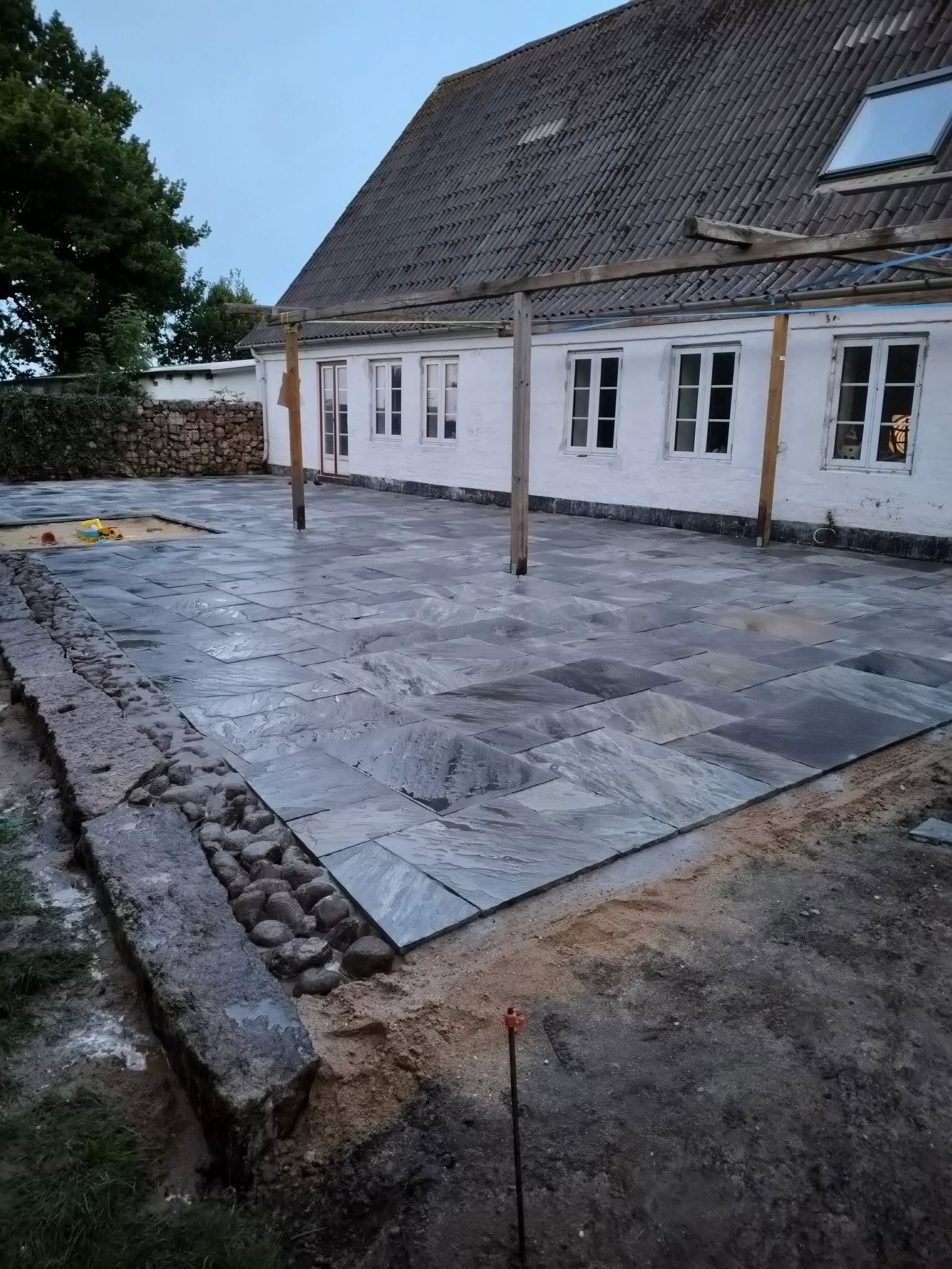 terrasse med flisebelægning og anlæg af have